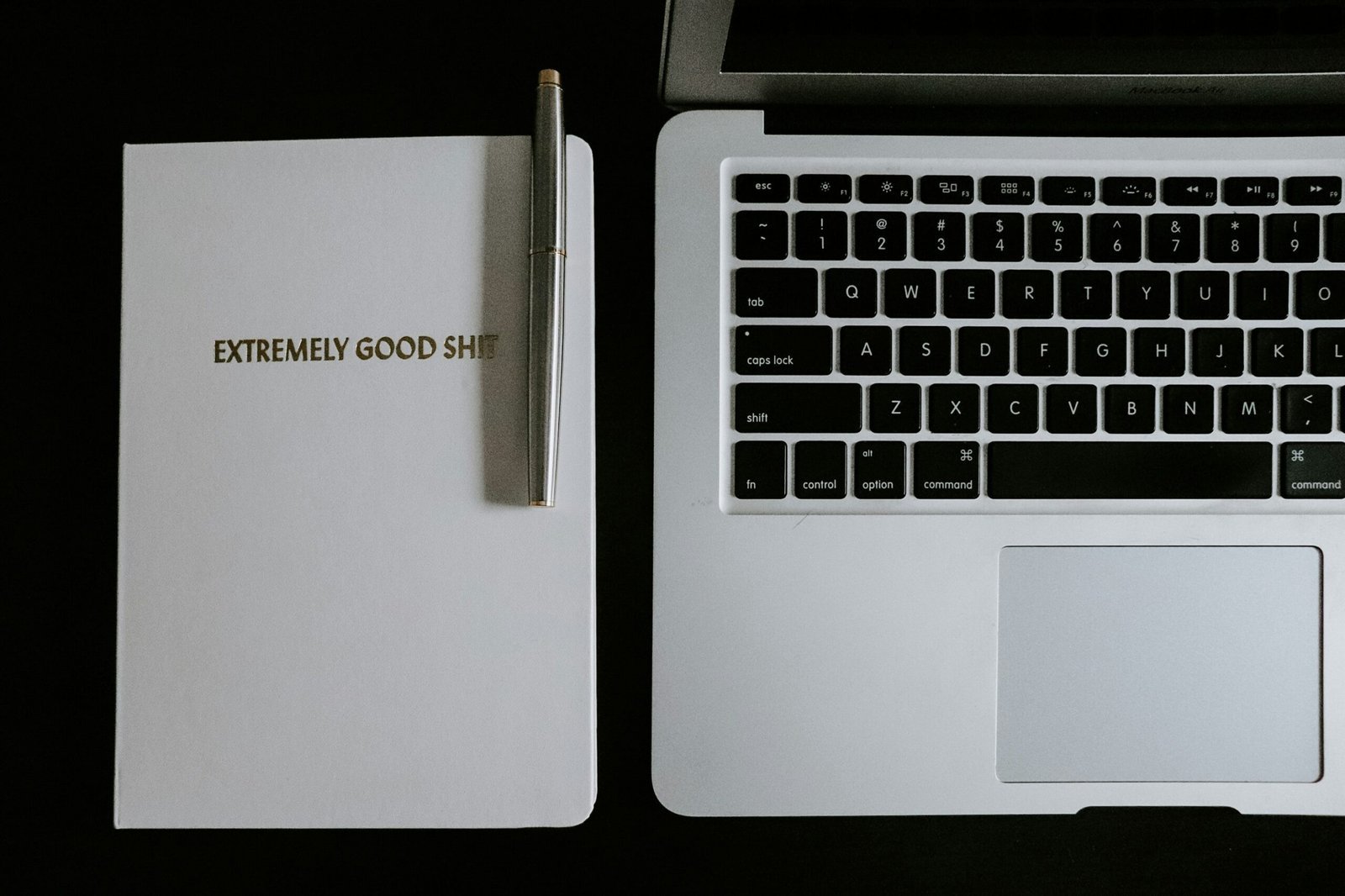 macbook pro beside black pen