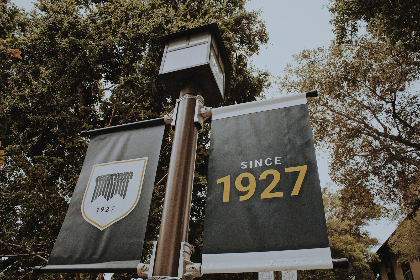 a street sign with two banners hanging from it's sides